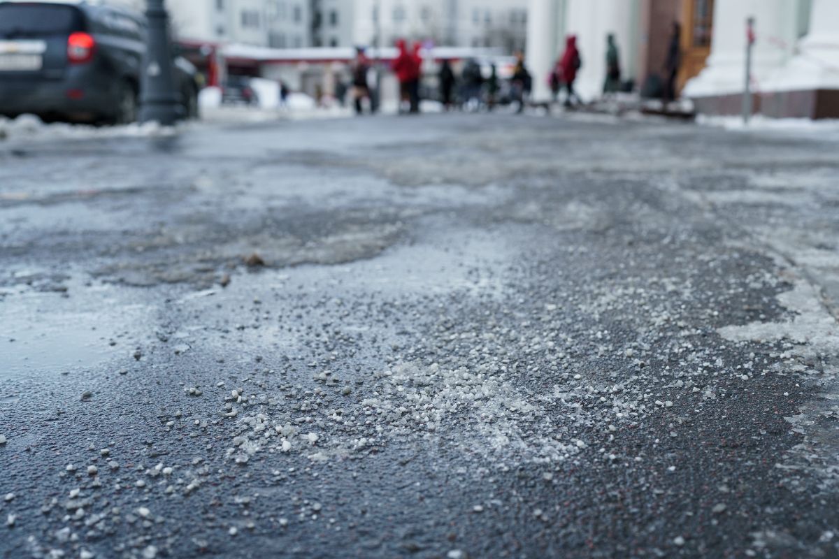 A street covered in ice with pedestrians carefully walking along its surface, showcasing winter conditions.